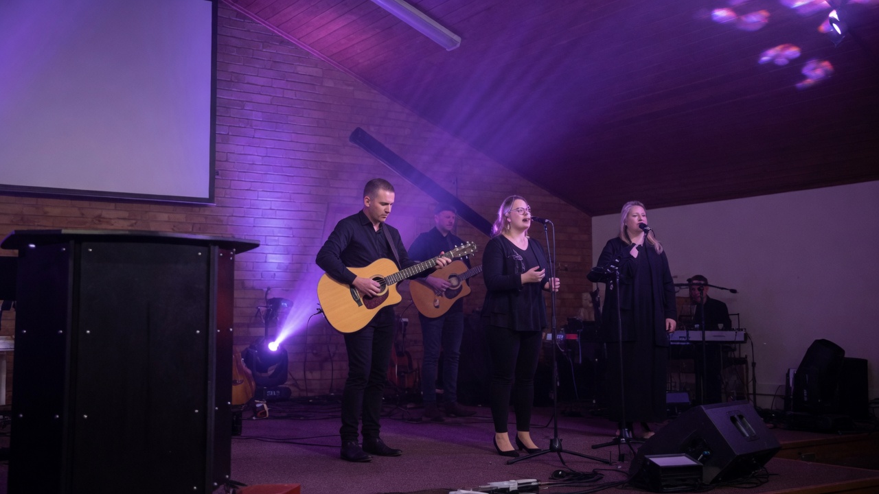Aanbidding met kitaar en sang in die saal